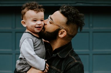 Father kissing toddler son