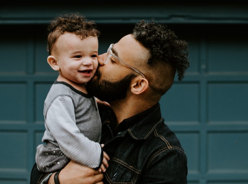 Father kissing toddler son